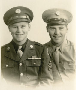 Sgt. Roland Ferron, left, and his brother Daniel in their respective military uniforms, c. 1945. Roland wears a uniform of the 13th Air Force and is decorated with the Navy's Presidential Unit Citation.