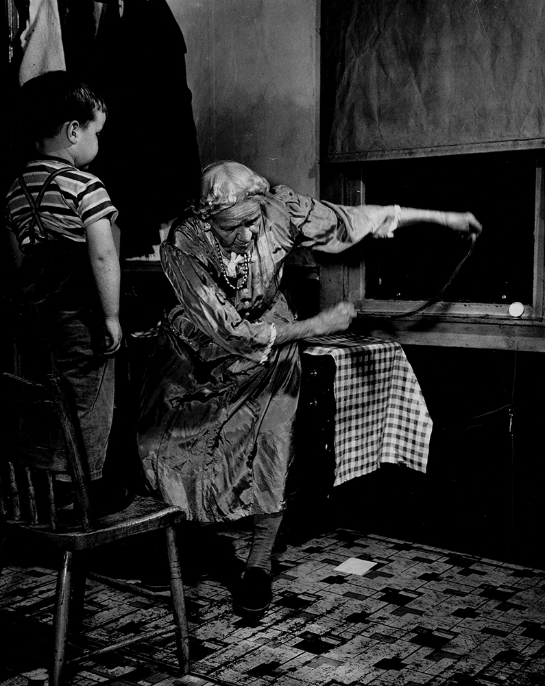 Sophia Bailer demonstrated the powwow ritual for curing wildfire for Don Yoder’s camera in 1950. Here, she transfers the illness to a red woolen string by drawing it along the child’s body and then sweeps the string away from the body three times, while addressing the illness and commanding it to depart: “Wildfeier, Wildfeier, Flieh, Flieh, Flieh! Der rote Fadem jagt dich hie, hie hie!” (“Erysipelas, Erysipelas, Fly, fly, fly! The red string chases you away, away, away!”).