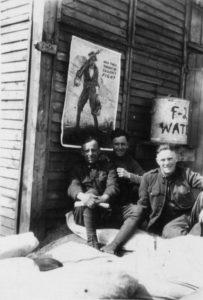 A group of three 28th Division soldiers rest beside a barracks building in France in early 1919. The poster And They Thought We Couldn’t Fight is tacked to the wall above and behind the three doughboys in the photo. Such posters made in the United States were also used overseas to increase morale of the troops in the field.