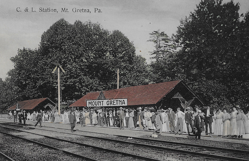 Crowds of people wait to board the train at Mount Gretna Station after spending a lively day at the amusement park in its early years. Mount Gretna Area Historical Society