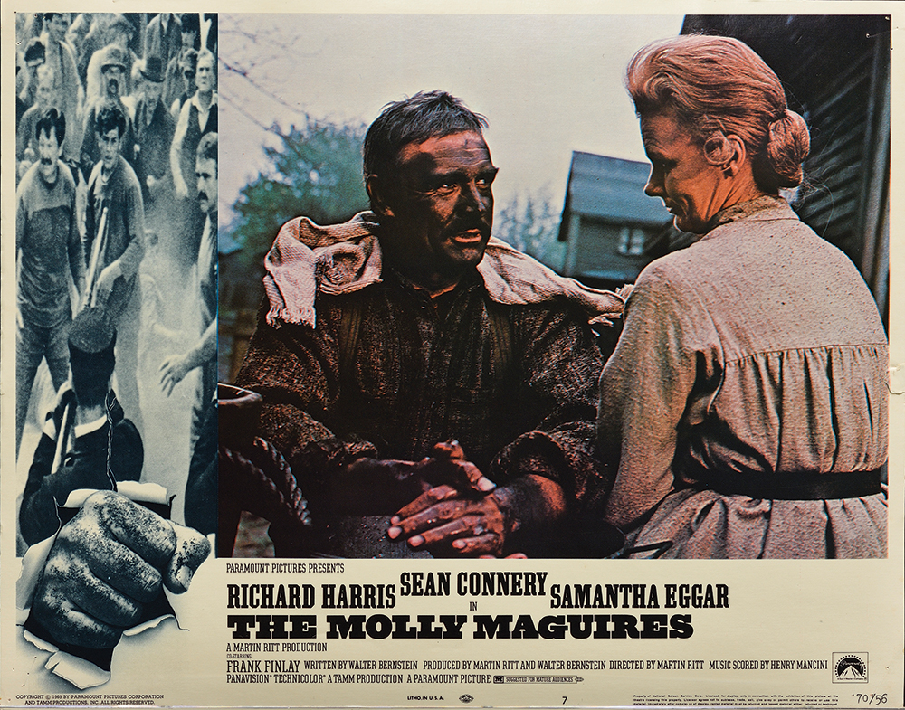 Lobby card for The Molly Maguires of a scene featuring Sean Connery as John Kehoe and Bethel Leslie as his wife, with Eckley buildings in the background. Eckley Miners' Village