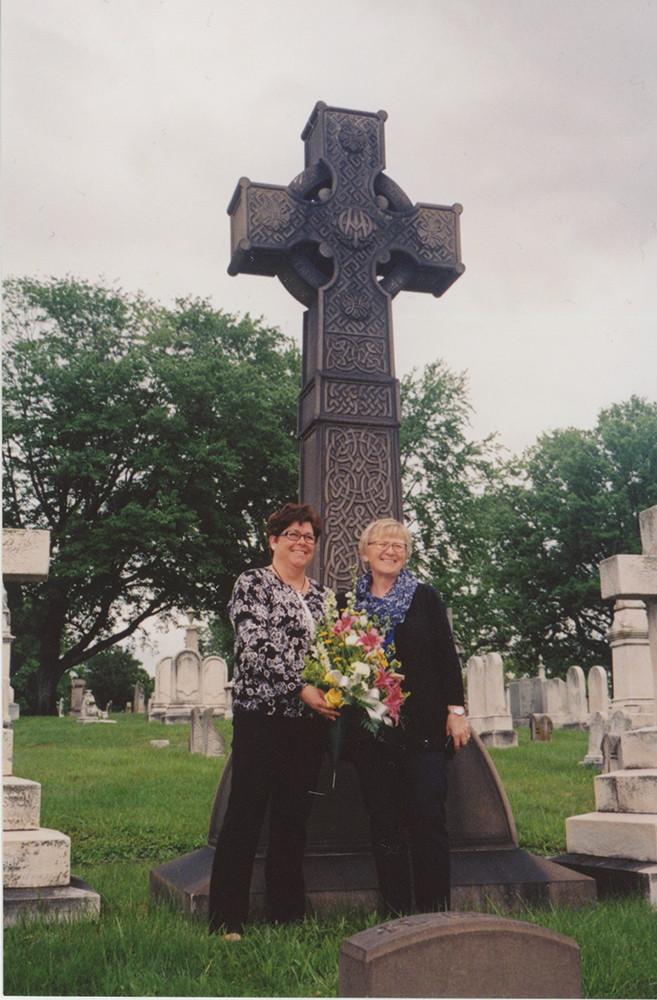 Dawn Luzetsky and Judith Rohde, nursing directors at the Johns Hopkins Hospital Children's Center, place flowers at Harriet Lane Johnston’s grave in Baltimore's Green Mount Cemetery. Photo by Jack Brubaker