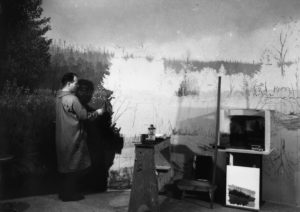 Artist Jerome Connolly paints the curved back wall of the elk diorama. He also painted the background for the mountain lion and gray fox dioramas. The State Museum of Pennsylvania