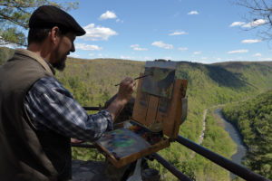 Artist Sean Murtha paints Pine Creek Gorge at Colton Point State Park, which is the backdrop for the wolf diorama.