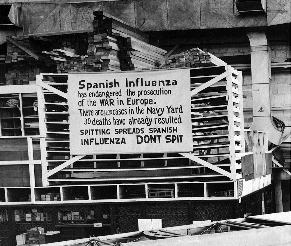 Signs warning about the dangers of spitting, such as this one photographed at the Naval Aircraft Factory in Philadelphia on October 19, 1918, were posted shortly after the outbreak of the epidemic. U.S. Naval History and Heritage Command