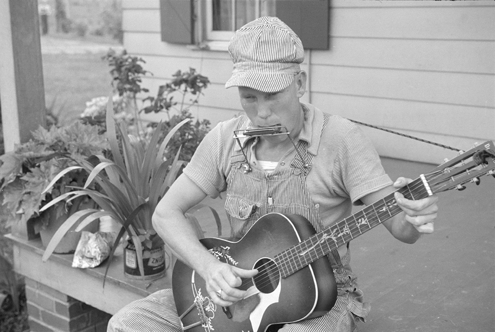 Country music had grassroots origins in Pennsylvania. This photograph by Ben Shahn for the Resettlement Administration was taken at Westmoreland Homesteads, a model subsistence community created through a New Deal program for laid-off coal workers. Here a young resident plays guitar and mouth organ, 1937. Library of Congress