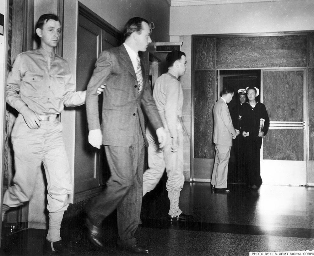 Saboteur Heinrich Heinck is led through a corridor in the Department of Justice by guards during the trial. FBI