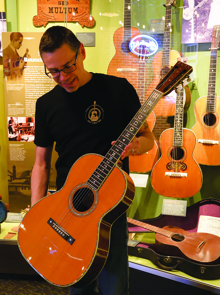 Martin archivist Jason Ahner holds Jimmie Rodgers’ custom OOO-45 guitar, with mother of pearl inlay for Rodgers’ name on the fingerboard and “Blue Yodel” on the headstock. Guitar, C. F. Martin & Co. Collection / Photo, PHMC