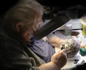 Helen Badulak applies patterns to the surface of an ostrich egg with a traditional wax resist technique using a kistka. Pennsylvania German Cultural Heritage Center, Kutztown University