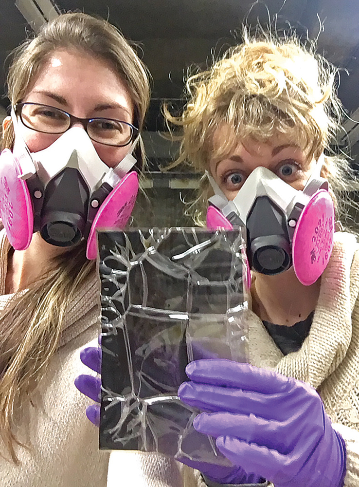 Archivists Megan Rentschler and Megan Evans inspect a negative in preparation for conservation. Photo, PHMC