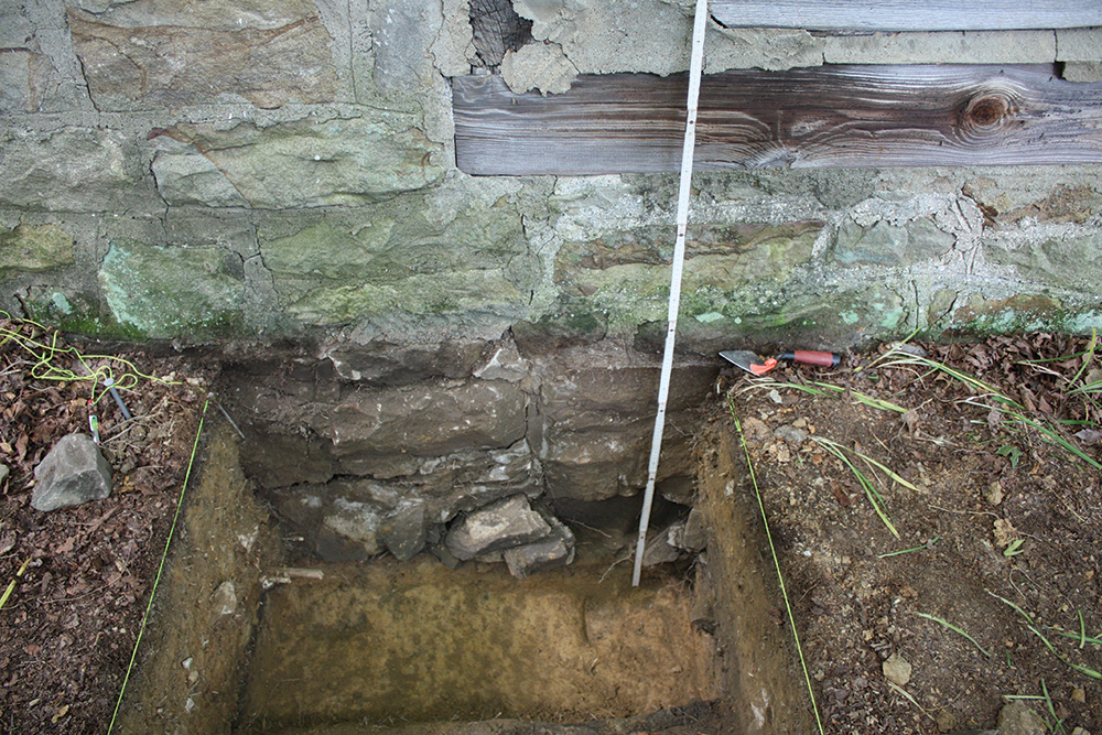 In this test unit excavation along the western wall where the log home and the addition meet, a visible “seam” of the original foundation under the log home, right, is aside the abutting addition’s foundation, left. Photo, Katherine Peresolak