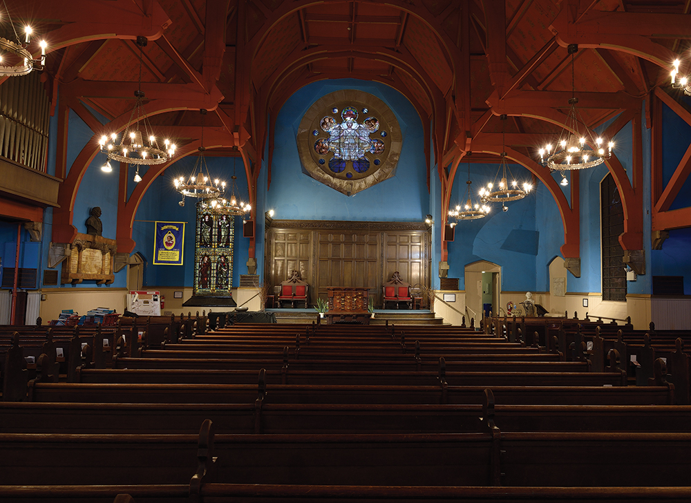 First Unitarian’s arched trusses echo those of Rodeph Shalom and allow unobstructed sightlines in the broad sanctuary, as seen in this view from the front entry, across pews, and toward the chancel. Photo, PHMC