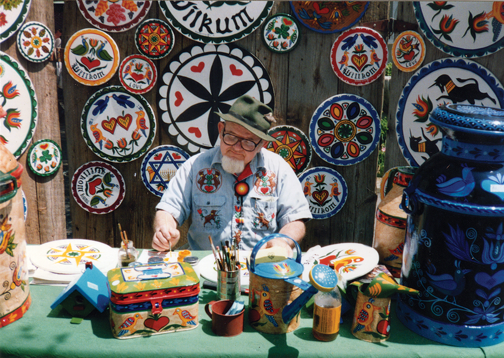 The celebrated barn star and hex sign painter Johnny Claypoole of Lenhartsville painting at an outdoor festival and displaying a wide range of patterns. Claypoole was the protégé of Johnny Ott, and he carried on many of Ott’s original designs and techniques. Courtesy of Eric Claypoole