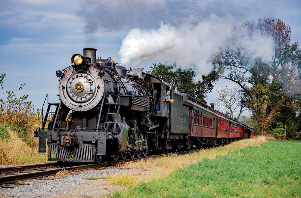 Strasburg Rail Road No. 90, a 2-10-0-type engine originally built by Baldwin in 1924 for hauling sugar beets in Colorado, easily lifts 10 passenger cars up the grade west of Groff’s Grove, Lancaster County, on October 12, 2019. Photo, Dan Cupper