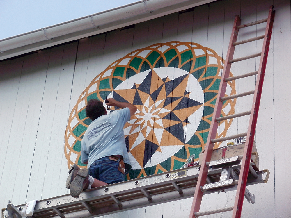 Eric Claypoole restores a 7-foot Milton Hill Star on the Sunday Barn, based upon the deeply weathered “ghost” on the surface of the barn wood. Photo, Patrick J. Donmoyer