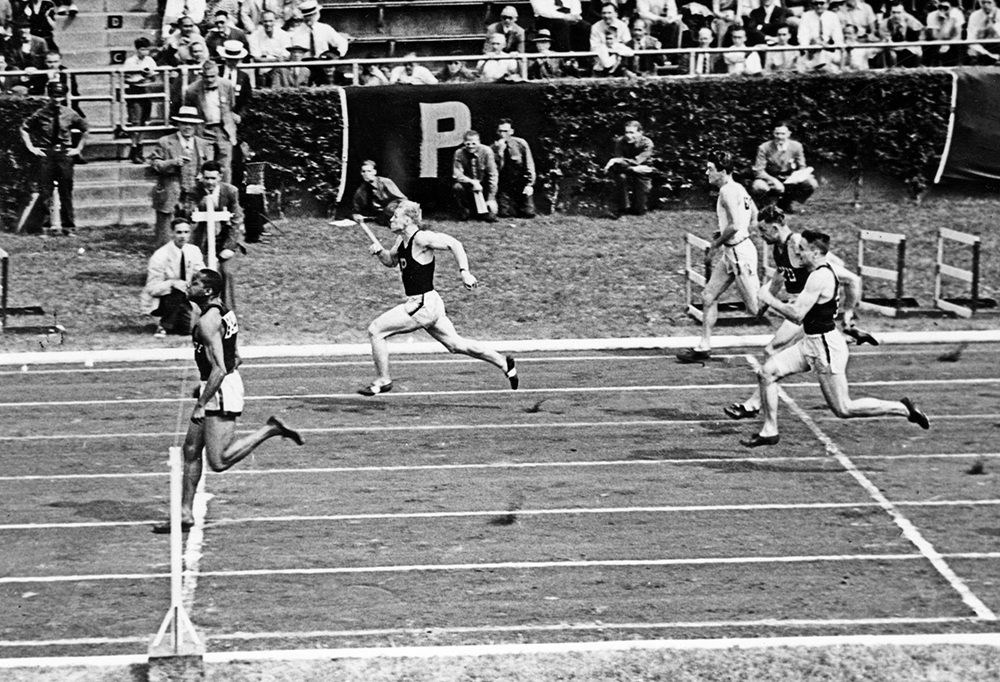 Ewell crosses the finish line about to break the tape in a sprint race for Penn State. Used with permission from the Eberly Family Special Collections Library, Penn State University Libraries
