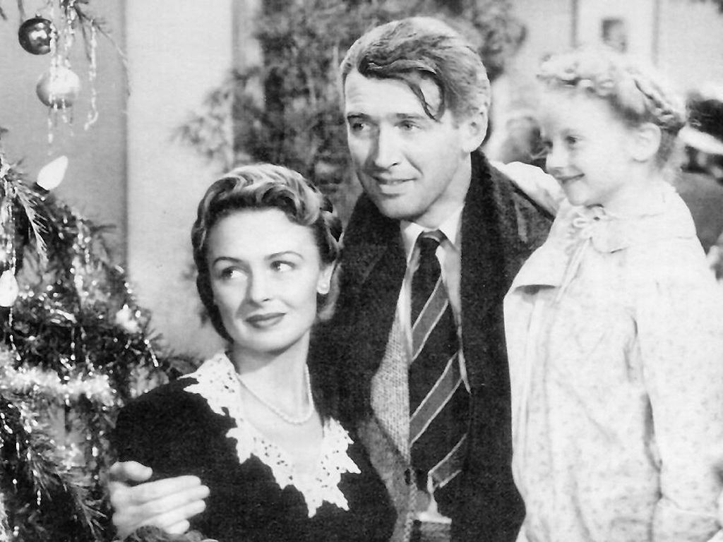 In the memorable closing scene of It's a Wonderful Life, James Stewart is embraced by Donna Reed, who played his wife Mary, and Karolyn Grimes, who played ZuZu, the couple's young daughter. Wikimedia Commons