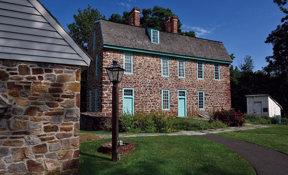 The exterior of the Keith House predates the Georgian style that dictated symmetry and balance, as shown in this view of the north side of the house today. The privy on the right is a reproduction of the one pictured in a lithograph of the estate in 1755. Photo, Graeme Park, PHMC
