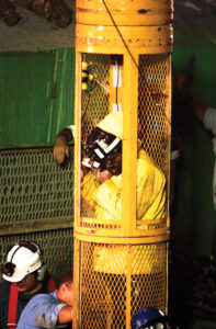 Randy Fogel, the first miner brought up from the mine, ascends in the yellow caged capsule. Pennsylvania State Archives, RG-20