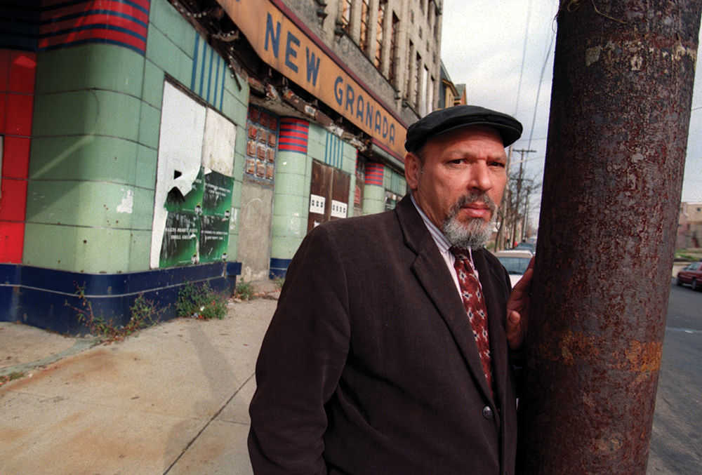 During a visit to his hometown of Pittsburgh in 1999, playwright August Wilson was photographed in front of the shuttered New Granada Theater on Centre Avenue in the city’s Hill District. The building had served as a movie theater and a venue for jazz musicians. Photo by Bill Wade. Copyright © Pittsburgh Post-Gazette, 2022, all rights reserved. Reprinted with permission.
