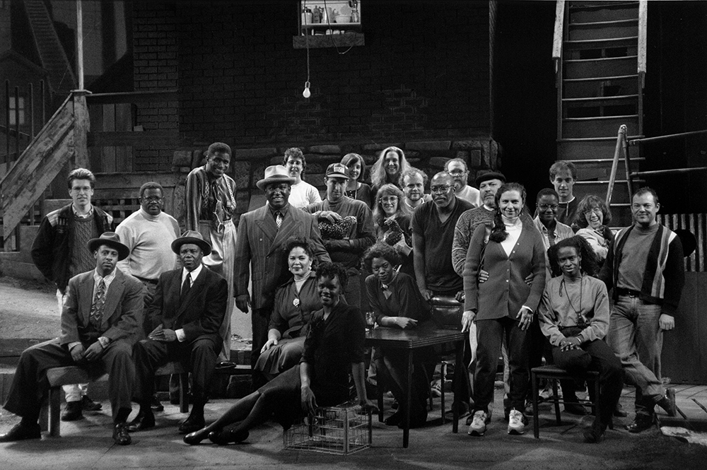 Wilson poses with the cast and crew of Seven Guitars at the play’s world premiere at Chicago’s Goodman Theatre in 1995. He is standing to the right of the table and is behind his wife, Constanza Romero-Wilson, who was the costume designer for the production. Courtesy of August Wilson Archive, University of Pittsburgh Library System