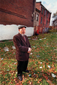 Wilson visits his childhood home at 1727 Bedford Avenue, the building to the far right, in Pittsburgh’s Hill District in 1999. Photo by Bill Wade. Copyright © Pittsburgh Post-Gazette, 2022, all rights reserved. Reprinted with permission.
