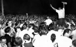 Jim Newell, right with megaphone, works up a crowd in front of the Myers family home in August 1957. Eight individuals with ties to his group, the Levittown Betterment Association, were later charged with harassment and criminal conspiracy. Courtesy of the Special Collections Research Center, Temple University Libraries, Philadelphia, PA