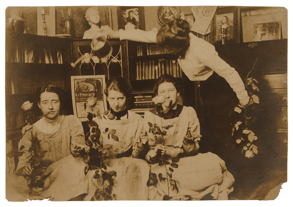 “The Red Roses,” Elizabeth Shippen Green, Violet Oakley and Jessie Willcox Smith are seated holding roses while Henrietta Cozens stands above them with a watering can. In the background is the poster designed by Oakley for the Plastic Club exhibition featuring the works of Green, Smith and Oakley. The photo was taken in their studio on Chestnut Street in Philadelphia, circa 1901, before their move to the Red Rose Estate in Villanova. Violet Oakley Papers, 1841-1981, Archives of American Art, Smithsonian Institution
