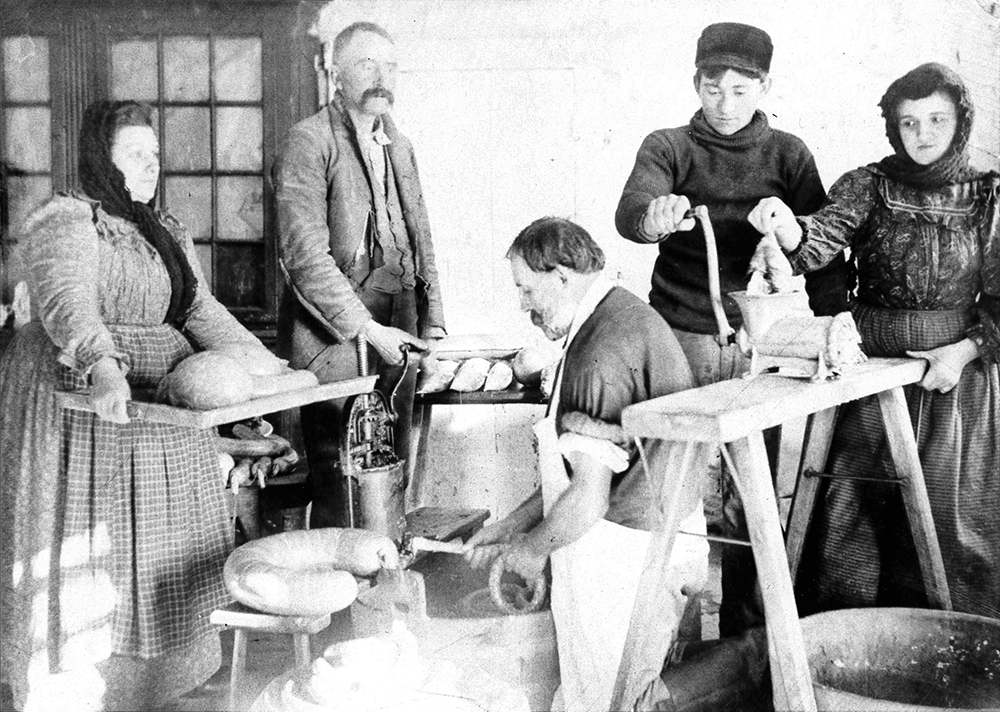 Butchering on New Year’s Day was a common custom, bringing together friends and family of all ages to join in the work of processing the meat to make traditional favorites like sausage and scrapple. This butchering scene was photographed by H. Winslow Fegley (1870–1944). Schwenkfelder Library and Heritage Center, Pennsburg