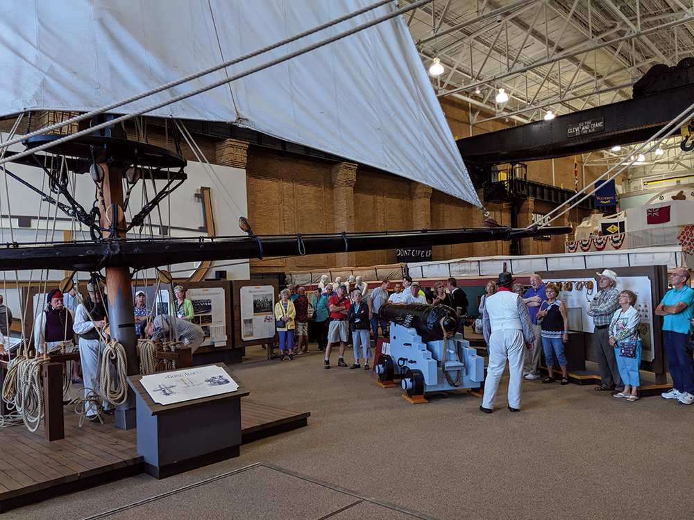 Museum visitors gather near the gun deck exhibit to view a demonstration of sail handling up close. Photo, Linda Bolla