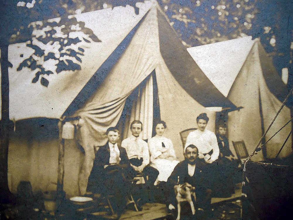 A family gathers in front of their tent at Mount Lebanon Campmeeting in the early 20th century. Notice the makeshift cistern on the left side of the tent. Courtesy of Mount Lebanon Campmeeting