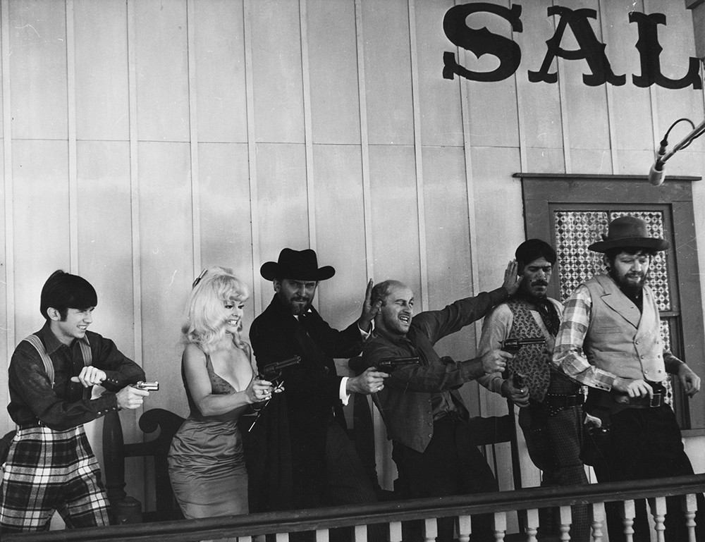 Archy (Jeff Siggins), LaBelle (Greta Thyssen), Judge Parker (Ray Reinhardt), Byrne Piven (Bill Stone), Wells Fargo Ferguson (Paul Benedict) and H.S. Stevens (Severn Darden) open fire on a bank robber. Karl Bissinger Papers, University of Delaware Library
