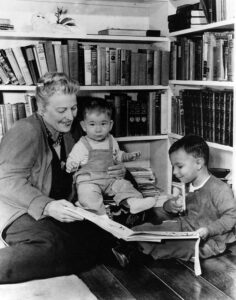 Pearl Buck reads to the first Welcome House children, Leon Yoder, in her arms, and David Yoder, in 1949. Pearl S. Buck International Archives