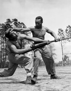 Marine Corps combat training at Montford Point included judo instruction. In this photograph, Cpl. Arvin Lou Ghazlo and Pvt. Ernest C. Jones demonstrate the technique to deflect a bayonet thrust. National Archives and Records Administration, 127-GC-404-5334