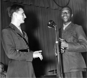 Pianist, singer and songwriter Bobby Troup, a native of Harrisburg, Pennsylvania, served in the Marine Corps at Montford Point and staged shows there. Here, he joins singer Finis Henderson at the microphone. Department of Defense (USMC) 6797