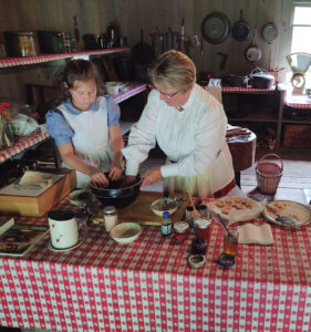 Costumed volunteers use the museum's cast-iron cookstove to make recipes from the past for visitors to sample. Pennsylvania Lumber Museum, PHMC