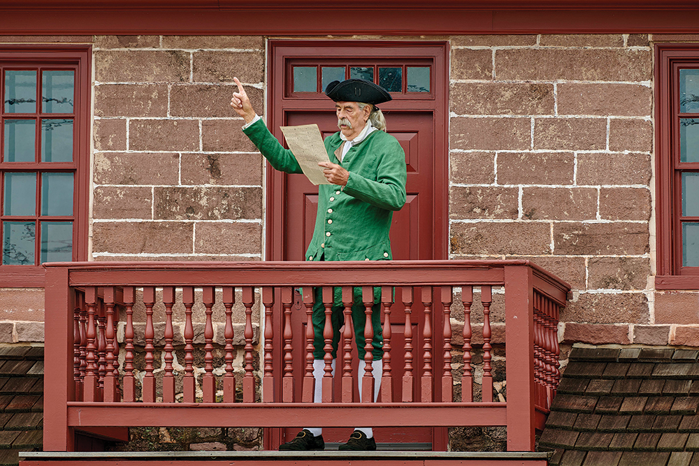 Volunteer Jim Reynolds reads the Declaration of Independence from the balcony of the Muhlenberg House. Historic Trappe / Photo, Dave Holsten